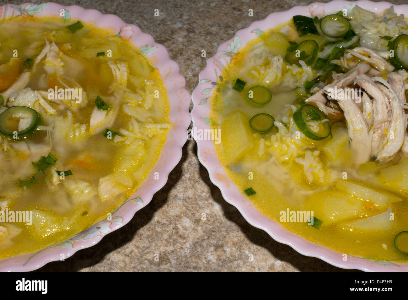 Zuppa di pollo con pasta e verdure in due piatti con cucchiaio. Bambini menu zuppa Foto Stock