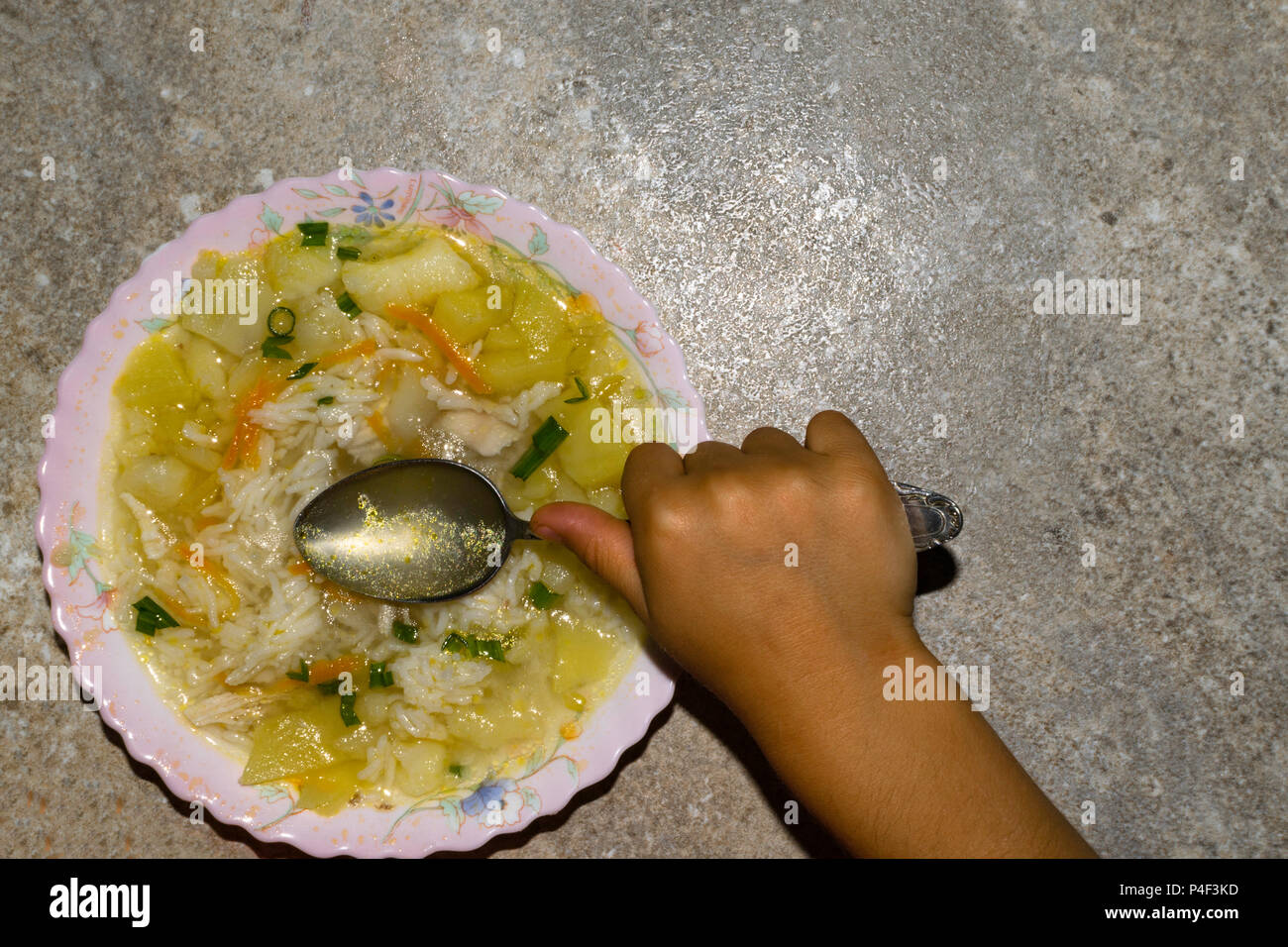 Zuppa di pollo con pasta e verdure in piastra. Tenere premuto per bambini cucchiaio a minestra Foto Stock