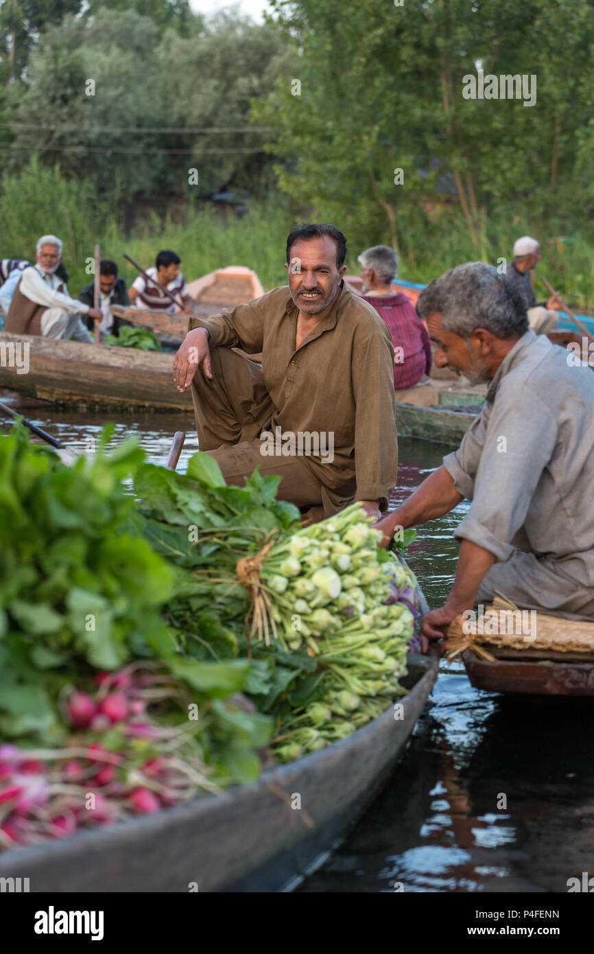 Srinagar, India - 16 Giugno 2017: Non identificato venditori vegetali tenendo i loro produrre per il mercato galleggiante di mattina presto su dal lago in Srina Foto Stock