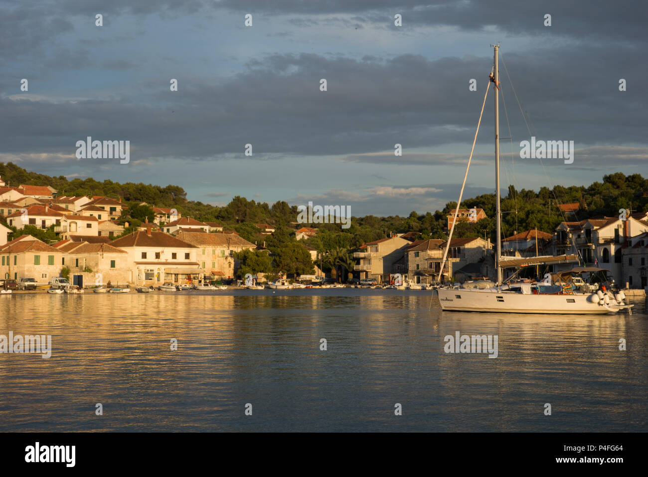 Un fotografo in cima al montante di uno yacht mentre all'ancoraggio, in Croazia Foto Stock