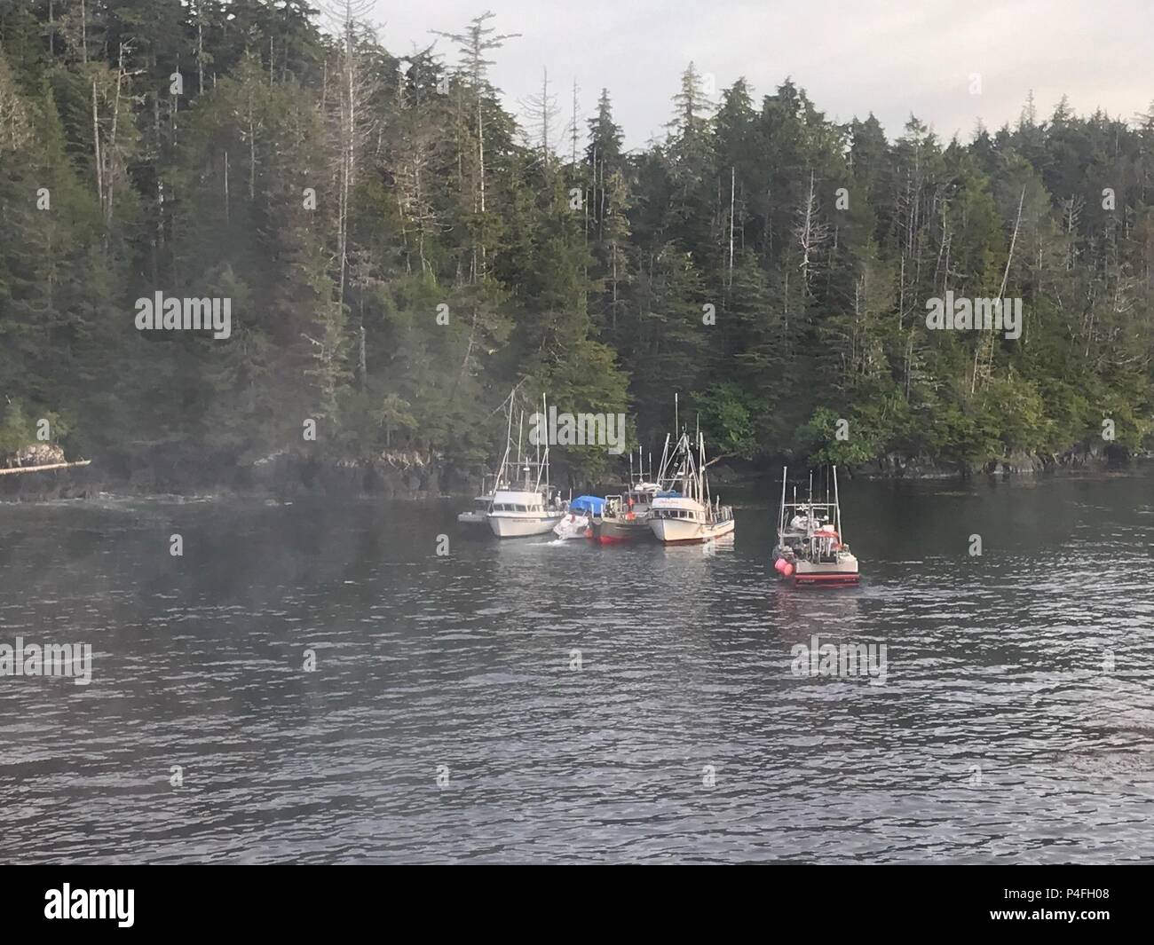 Buon Samaritano navi assistere tre adulti e tre bambini dopo la loro 27-piede cabinato cominciò a prendere su acqua vicino a Long Island nel Sitka Suono, Alaska, 19 giugno 2018. Una guardia costiera Stazione aria Sitka MH-60 elicottero Jayhawk equipaggio, un Sitka Fire di salvataggio e di equipaggio quattro buon samaritano equipaggi ha risposto a una chiamata mayday dal recipiente e assistito l'equipaggio e della nave di Sitka. Stati Uniti La guardia costiera della foto Foto Stock