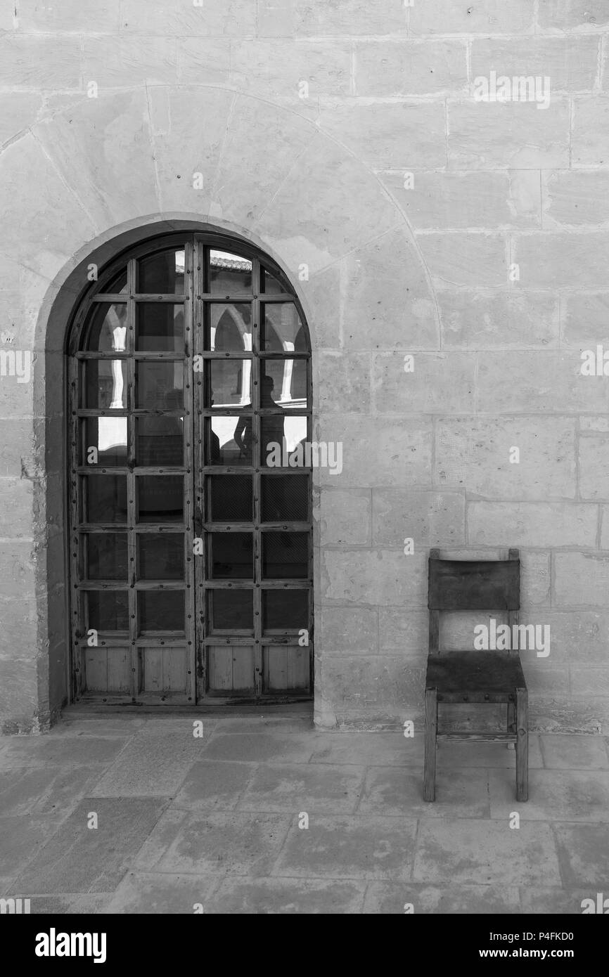 Antico monastero di scena sedia antica e porta in bianco e nero in Maiorca Spagna Foto Stock
