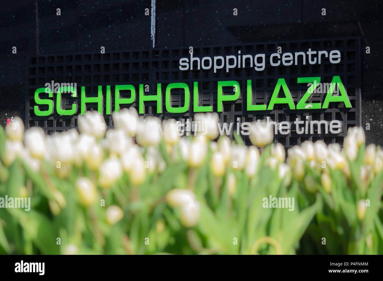 AMSTERDAM, PAESI BASSI - 02 MAGGIO 2018: Segnale fuori dal centro commerciale Schiphol Plaza all'aeroporto di Schiphol con tulipani defocusi in primo piano Foto Stock