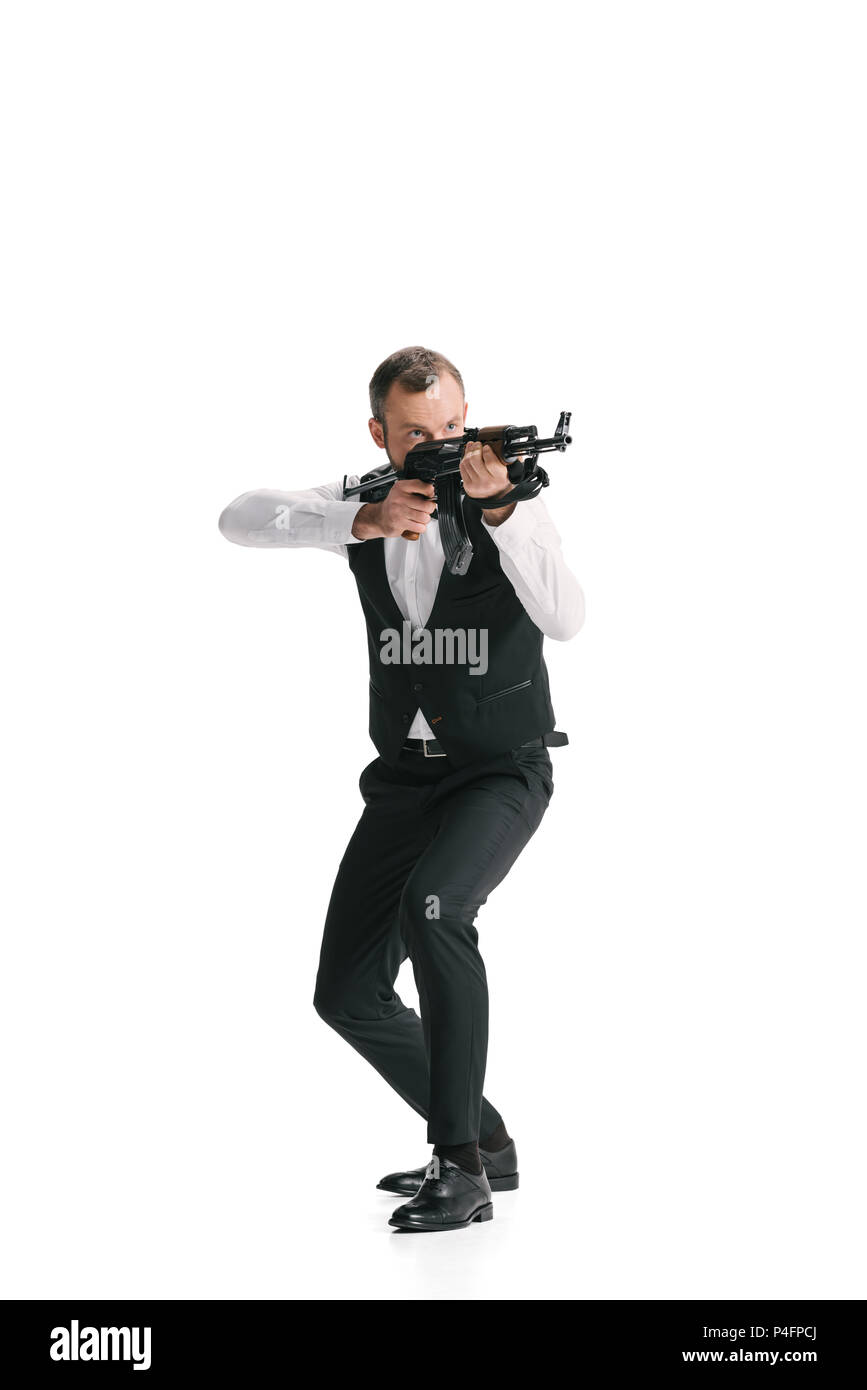 Agente segreto in tuta con un fucile mirando lontano isolato su bianco Foto Stock