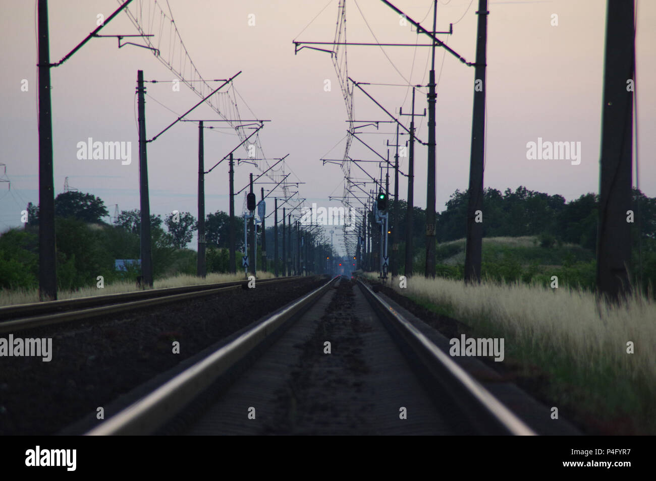 I binari ferroviari sul tramonto. Treni e piste di alimentazione elettrica. Foto Stock