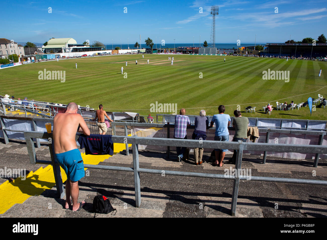 Uno spettatore guarda una prima classe county cricket su una torrida giornata calda a Swansea Foto Stock