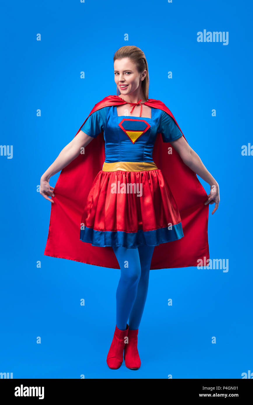 Donna attraente in costume da supereroe azienda capo isolato su blu Foto  stock - Alamy