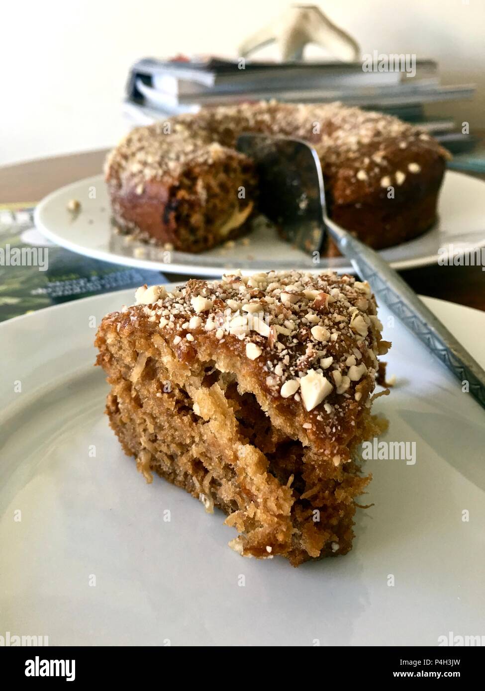 Round Stile bundt coffee cake, con cuneo di torta sulla piastra bianca sul tavolo per interni Foto Stock