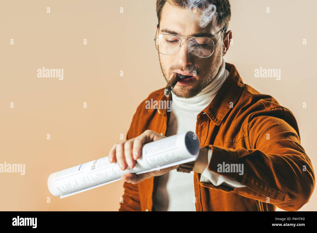 Ritratto di imprenditore con sigaro e giornale di controllo del tempo di guardia isolati su beige Foto Stock