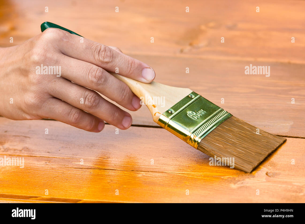 Pittura a mano di pannelli di legno con pennello, primo piano Foto Stock