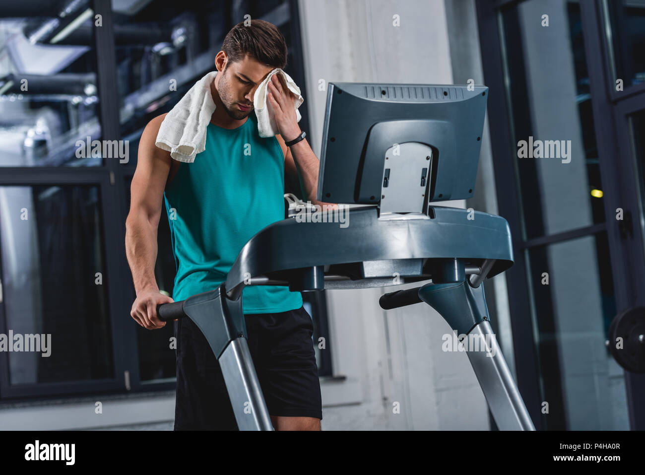 Uomo Che Si Pulisce Con L'asciugamano in Palestra Immagine Stock