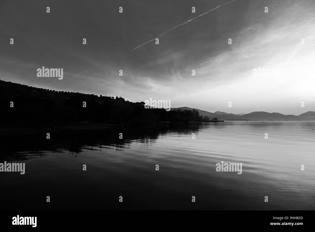 Bellissima vista del lago Trasimeno (Umbria, Italia), con colline e cielo riflettendo sull'acqua Foto Stock