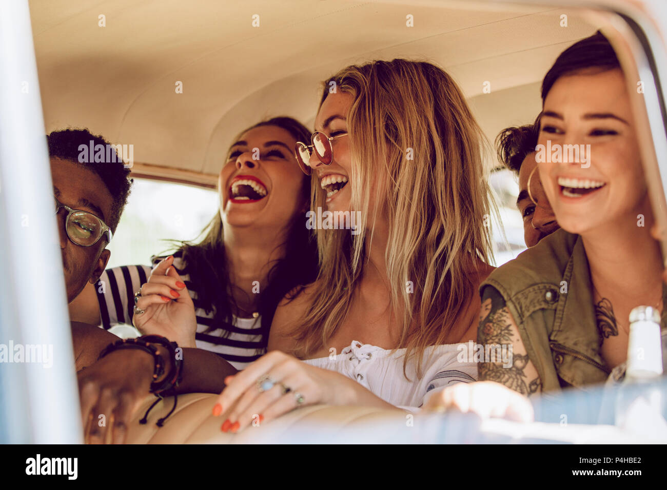 I giovani allegri godendo di un viaggio su strada. Uomo sorridente e donne su un viaggio godendo l'auto. Foto Stock