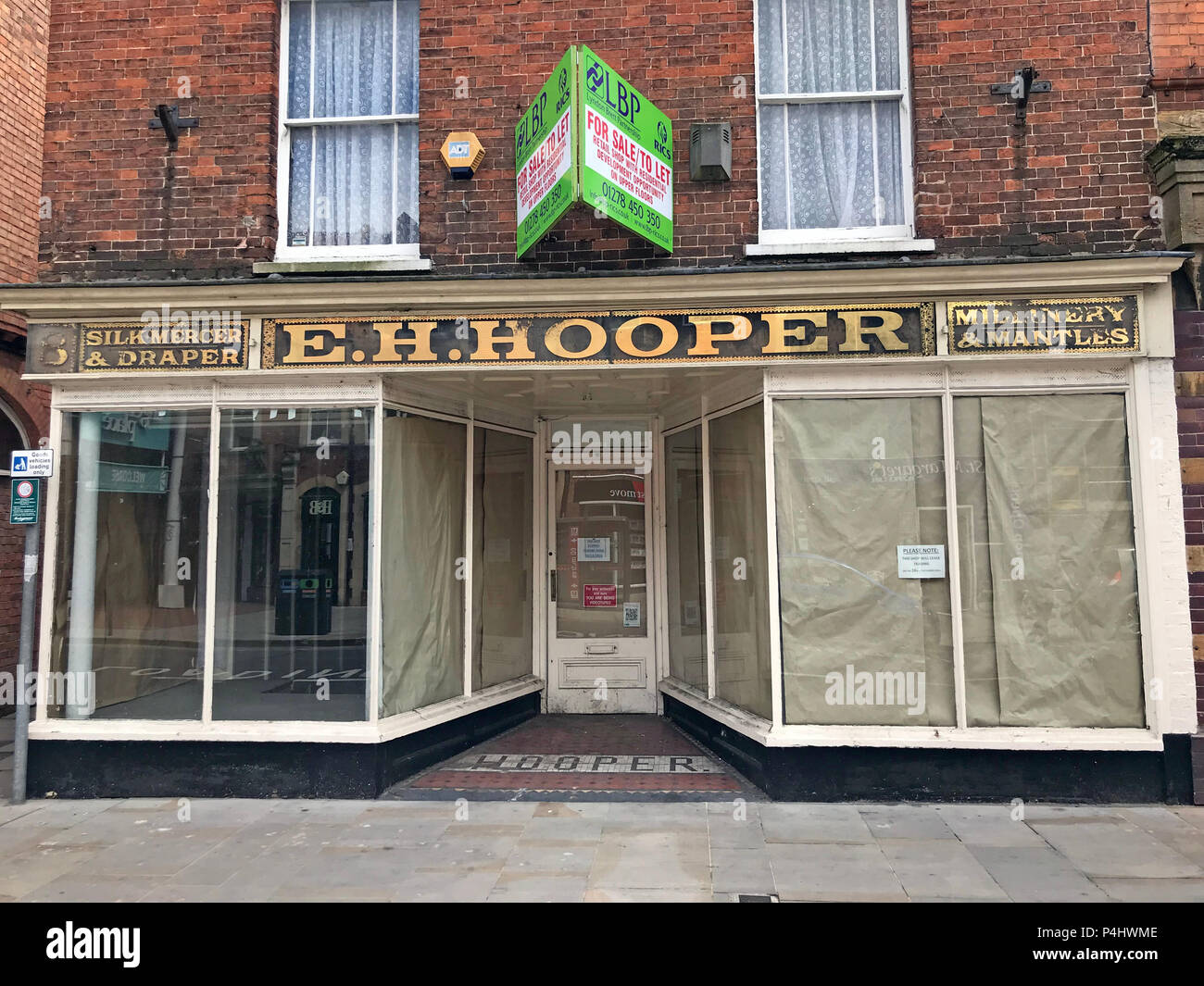 EH Hooper, seta Mercer & Mercier, Millinery & mantelli shop segno in oro di scritte, 25 High Street, Bridgwater, Somerset, Inghilterra, Regno Unito, TA6 3essere Foto Stock