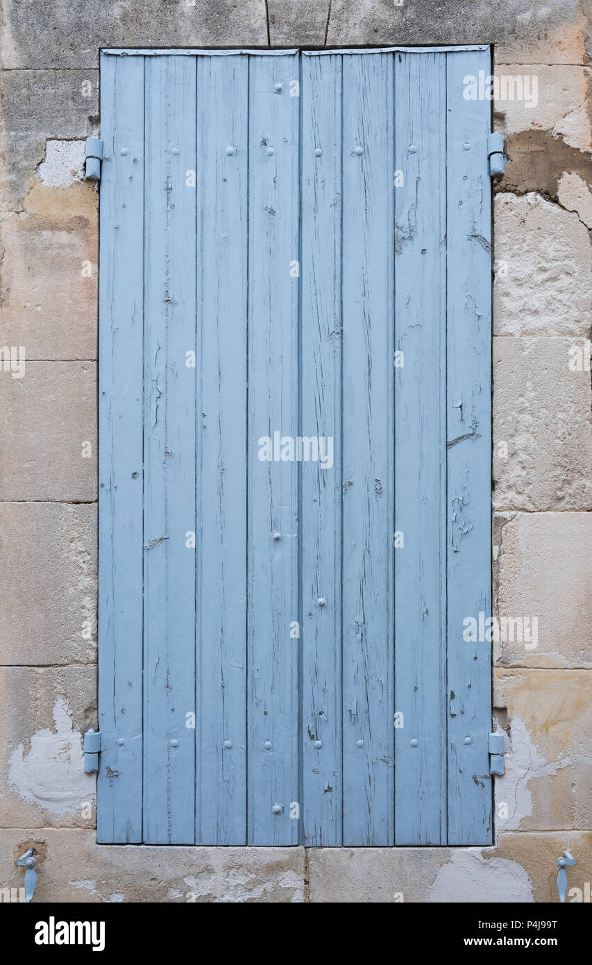 Luce blu vecchio serrande nella parete di roccia calcarea della Provenza francese house Foto Stock