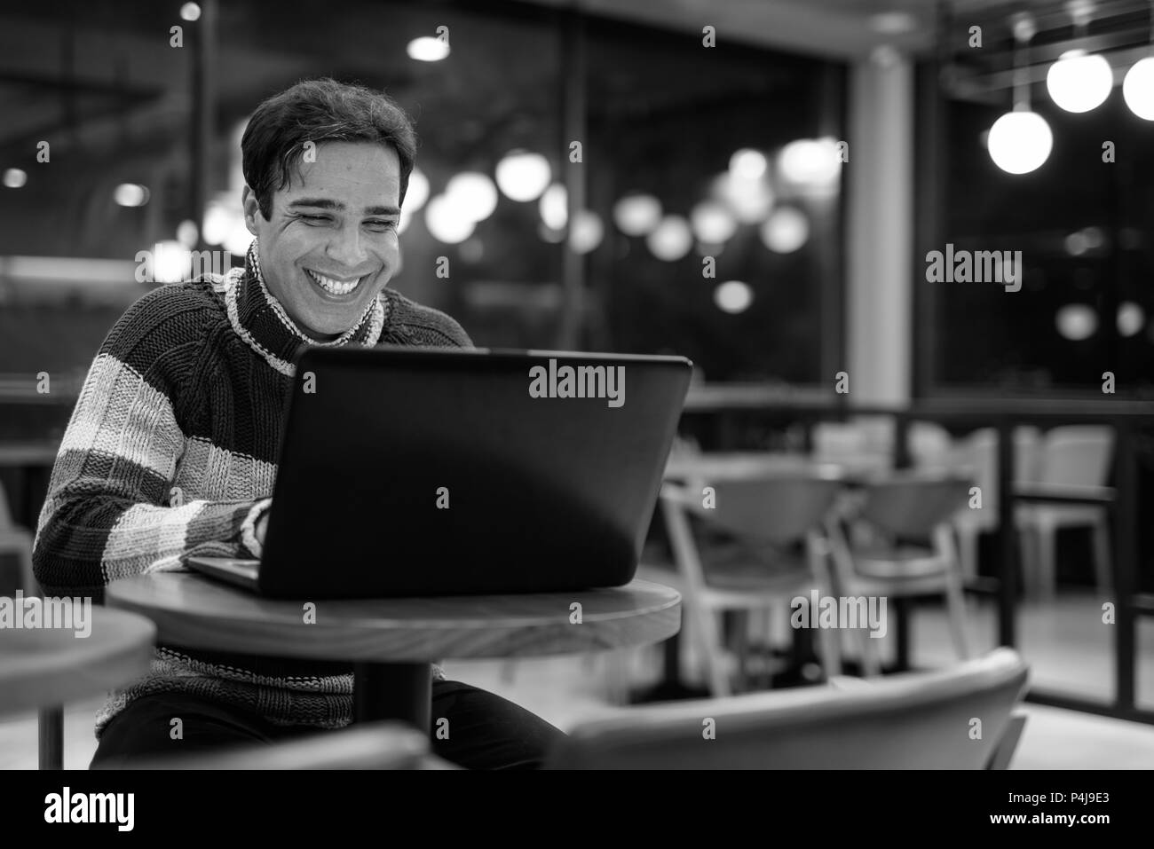 Uomo che utilizza computer portatile presso la caffetteria Foto Stock