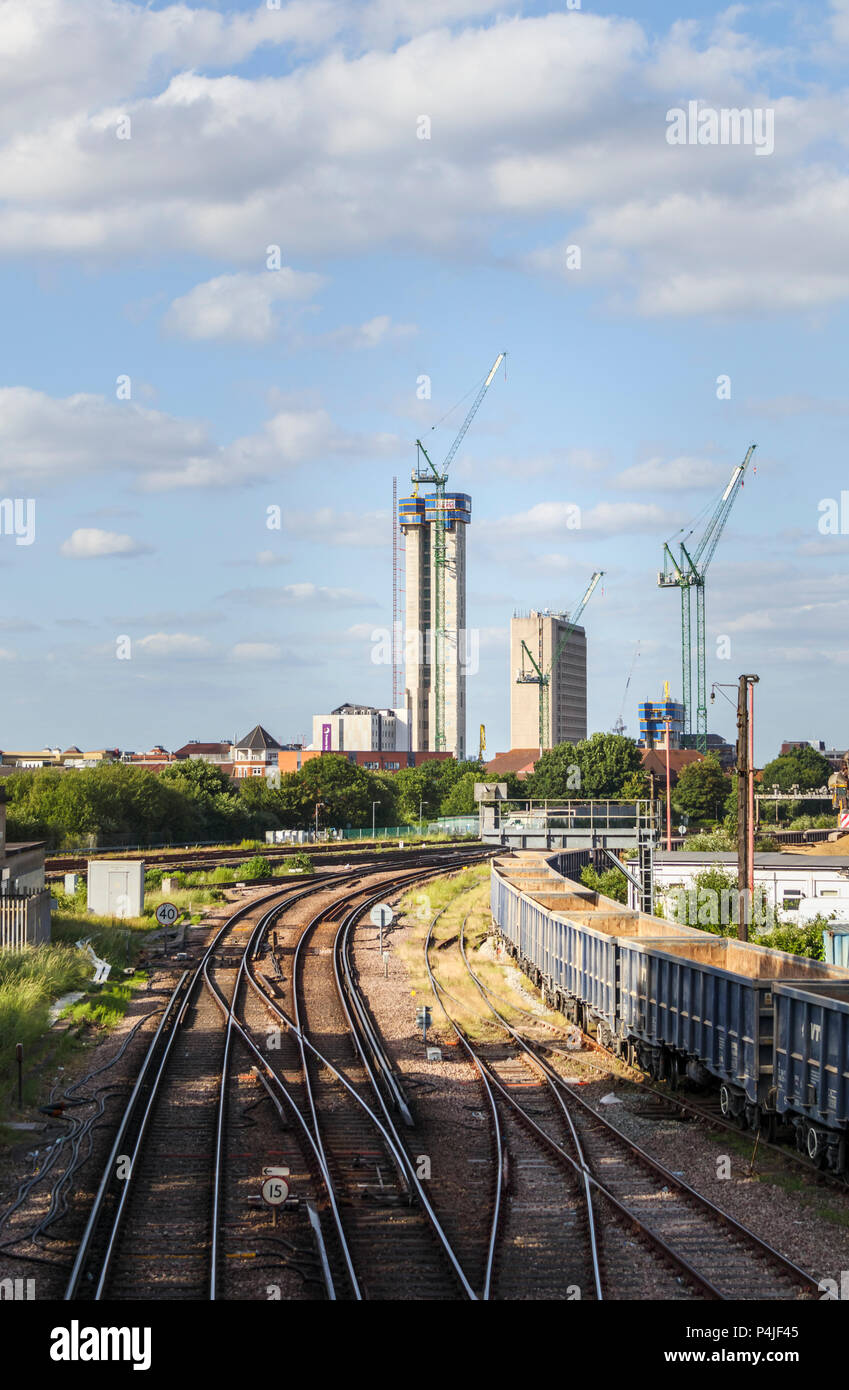 La modifica sullo skyline di Woking, Surrey: tracce ferroviarie il piombo in gru a torre e il nuovo alto luogo Victoria Square centro progetto di riqualificazione Foto Stock