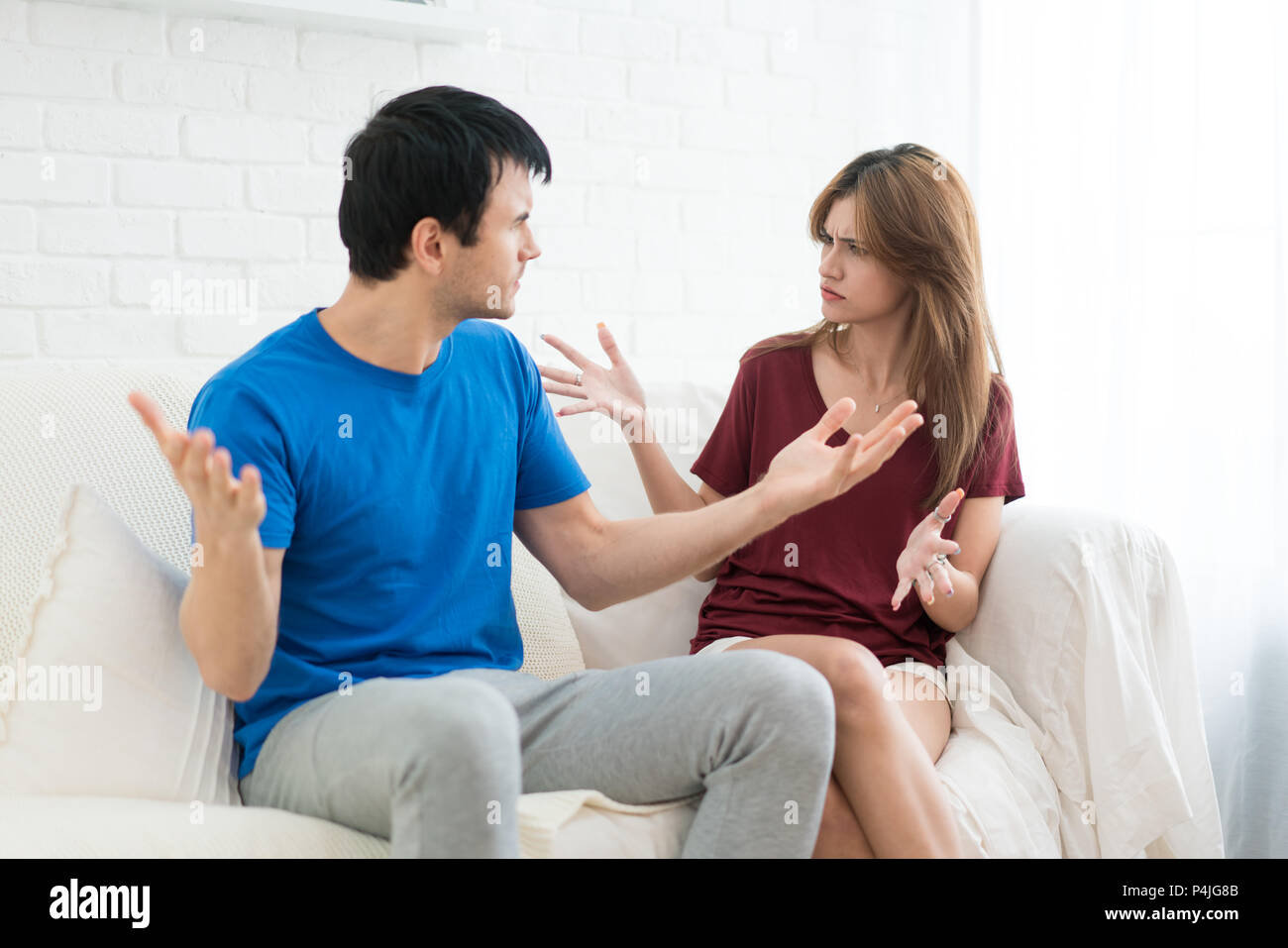 Giovane aventi argomento conflitto, cattive relazioni. Arrabbiato furia urlando donna uomo stress in casa. Foto Stock