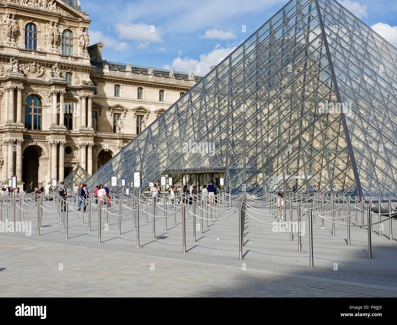 Un paio di persone al di fuori della piramide ingresso al museo del Louvre, con un sacco di spazio vuoto per i visitatori di line up, Parigi, Francia Foto Stock