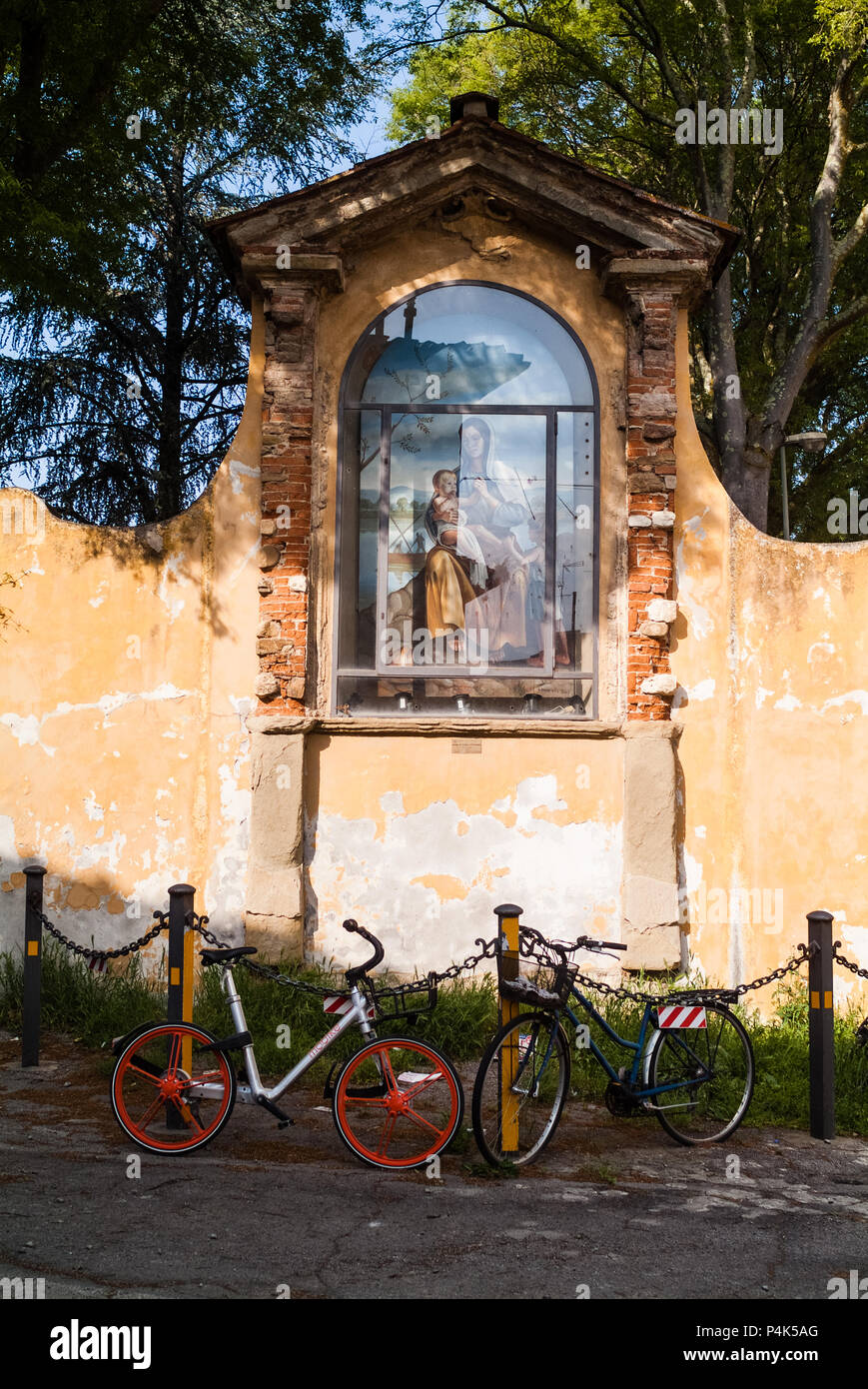 Firenze, Italia - circa aprile 2018 - Outdoor Vergine Maria assunta statua con lo sport biciclette parcheggiate. Area Rovezzano Foto Stock