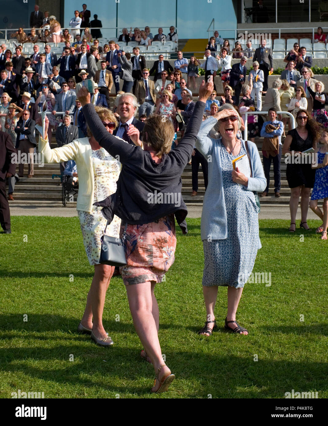 Racegoers reagire alla fine di una corsa di cavalli al Goodwood Race Course, vicino a Chichester in Gran Bretagna il 26 maggio 2018 Foto Stock