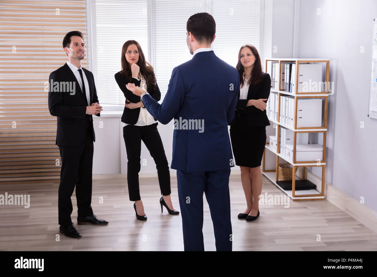 Manager con il suo giovane collega avente la discussione al lavoro Foto Stock
