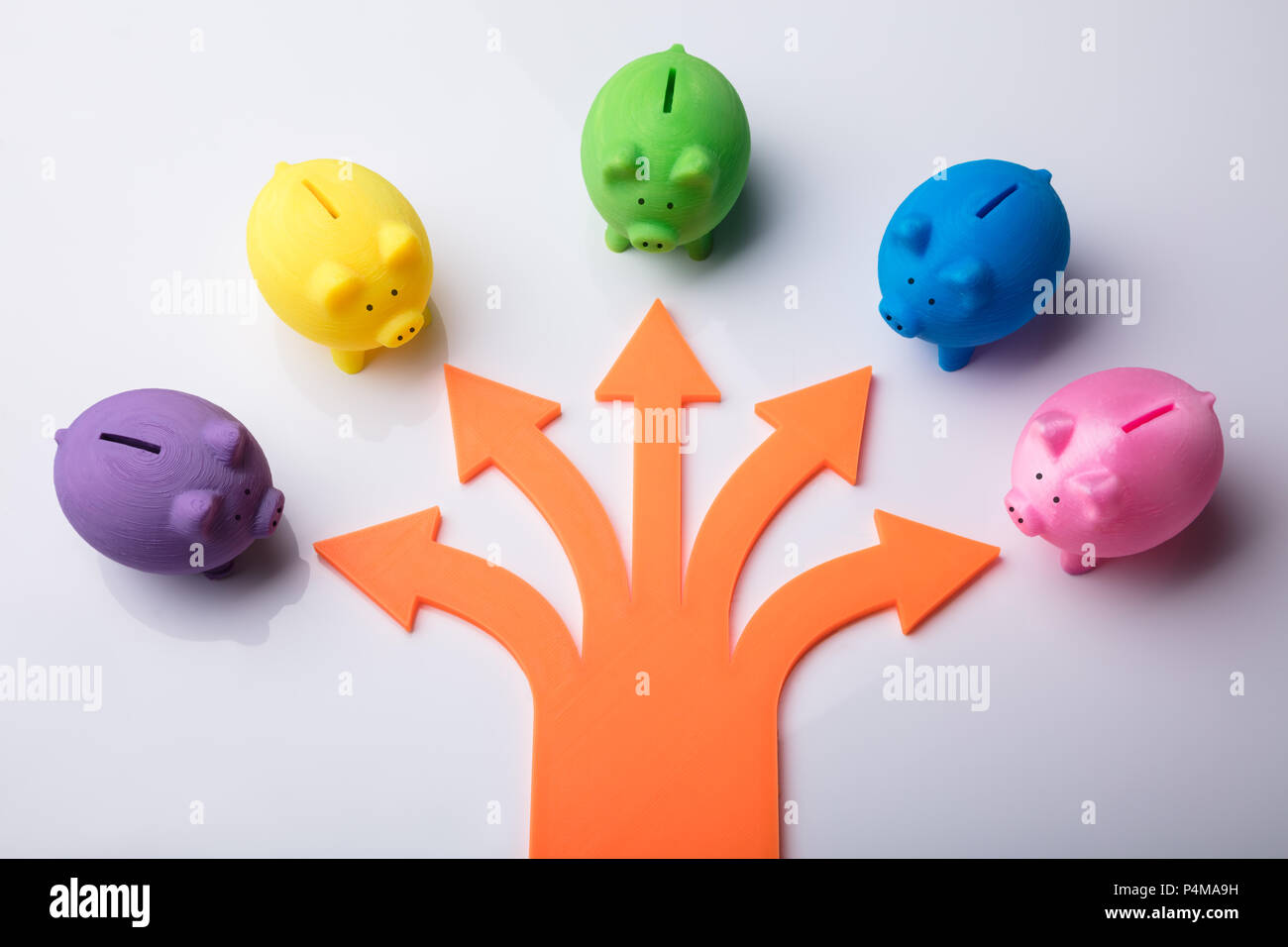 Vari simboli freccia mostra la direzione verso Piggybanks colorato su sfondo bianco Foto Stock