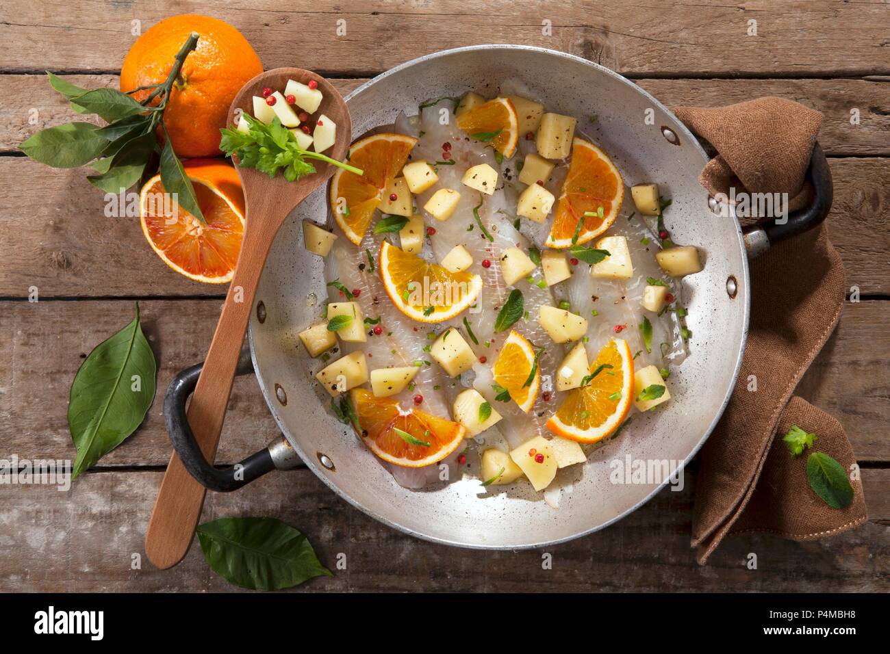 Platessa all'arancia (raw filetto di passera con patate, arancio e menta piperita, ital) Foto Stock