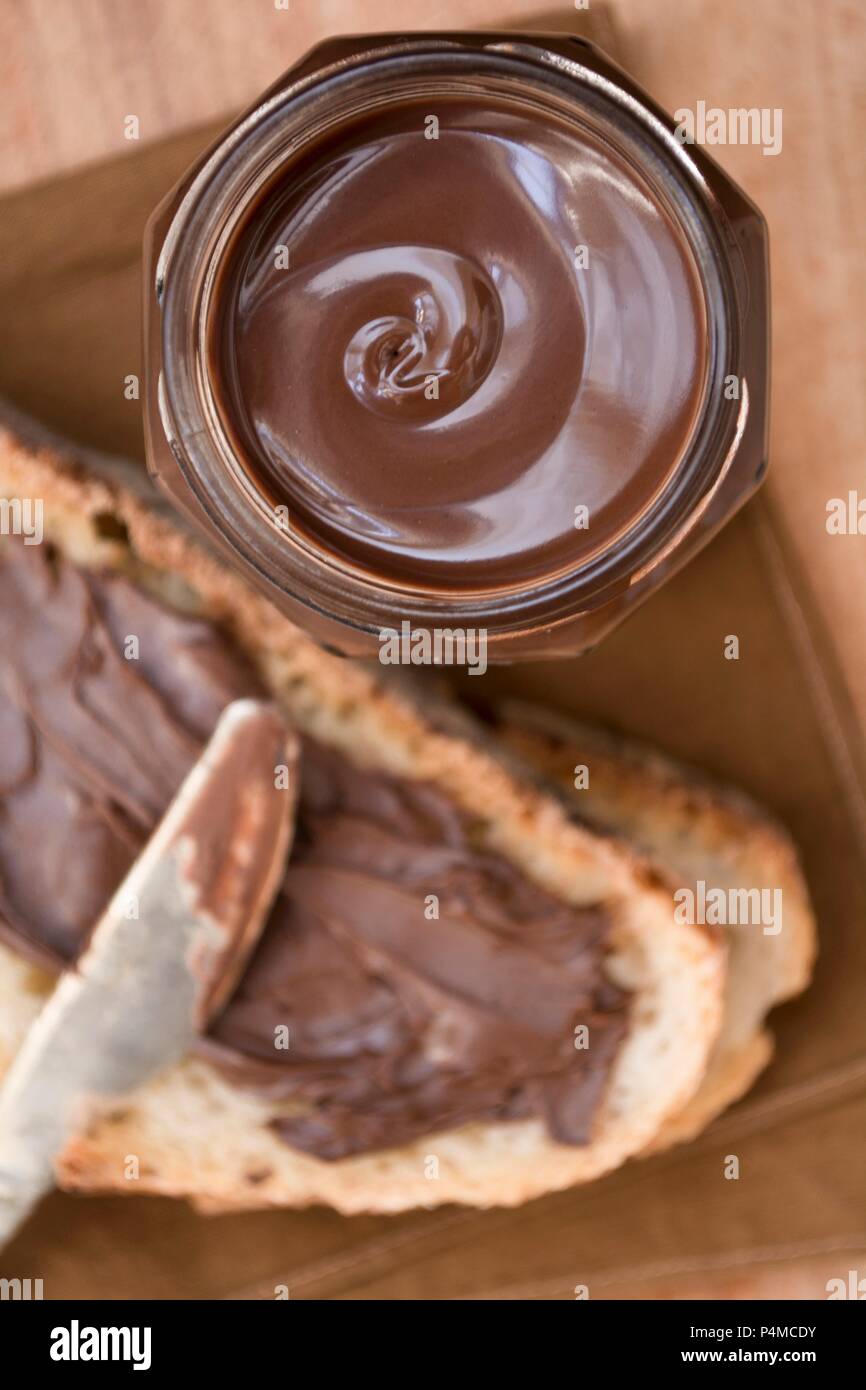 Cioccolato da spalmare in un vaso e sul pane Foto Stock