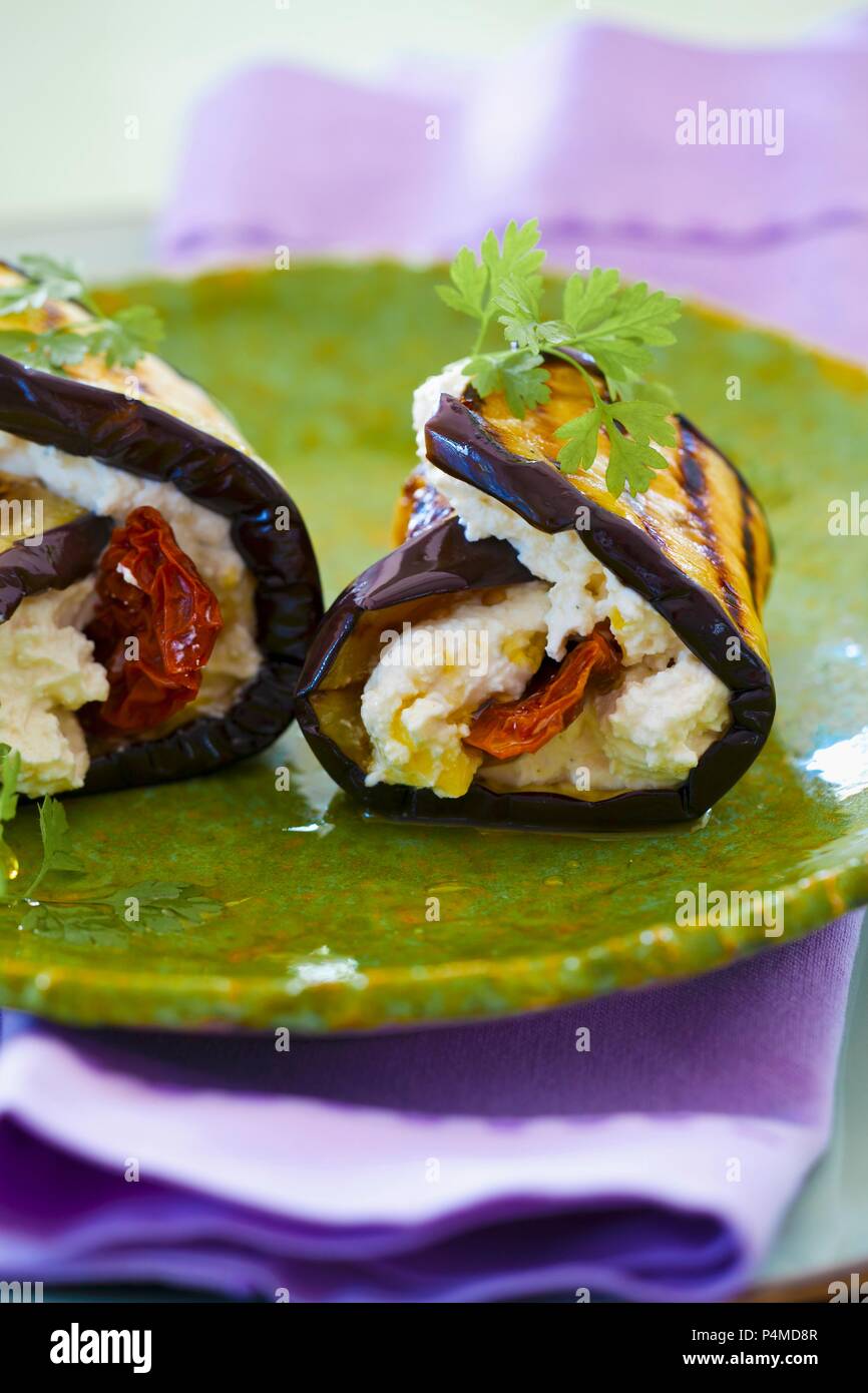 Rotoli di melanzane con caprino crema di formaggio, pomodori secchi e olio di oliva Foto Stock