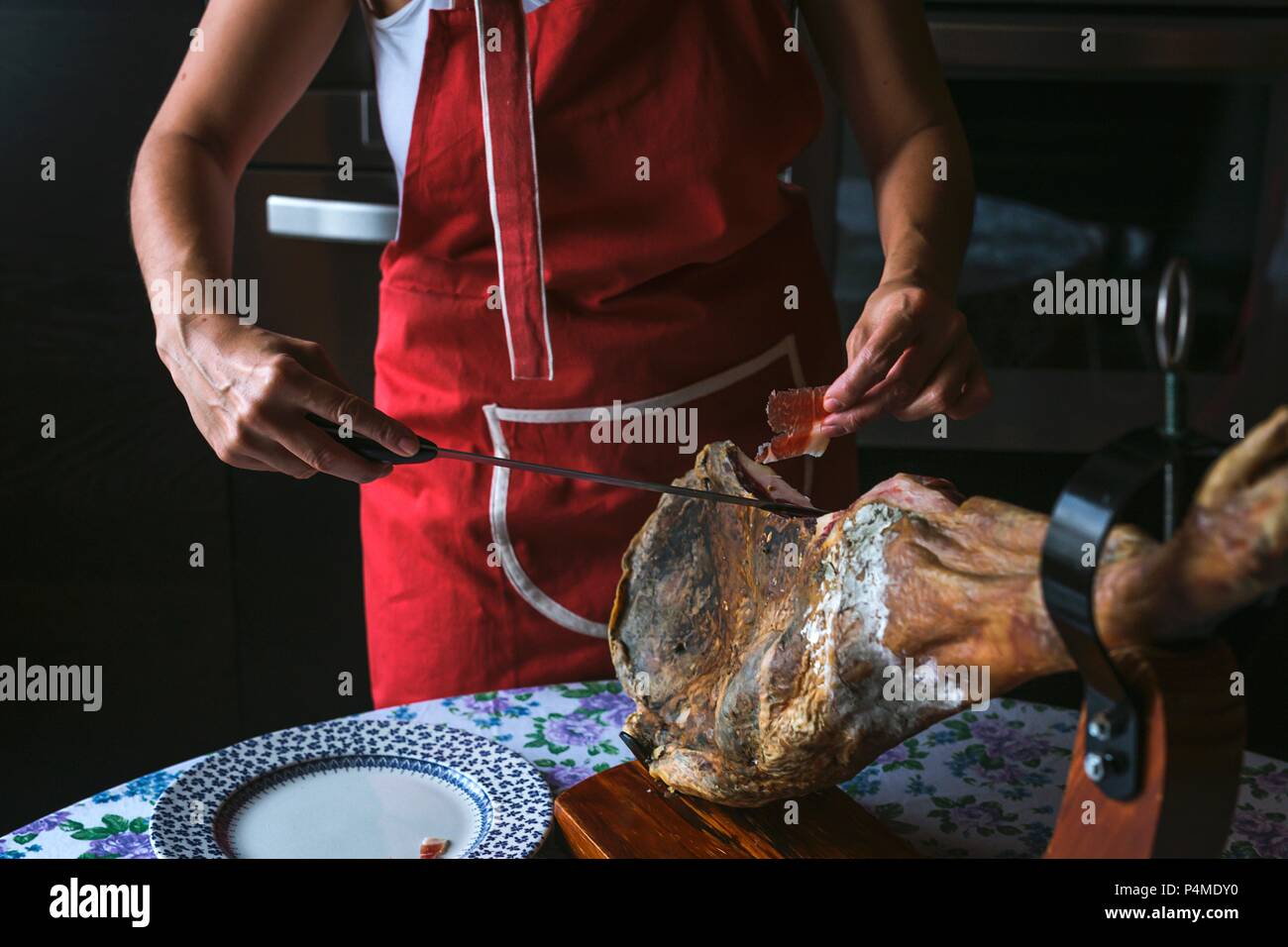 Donna irriconoscibili per affettare il prosciutto Serrano Foto Stock