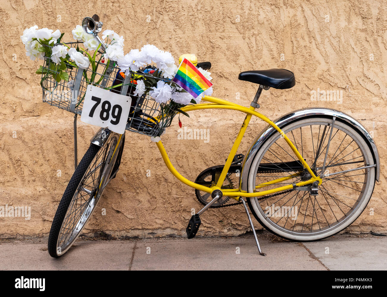 Colorate di " commuters " giallo bicicletta con fiori artificiali nel cestello anteriore; Salida; Colorado; USA Foto Stock