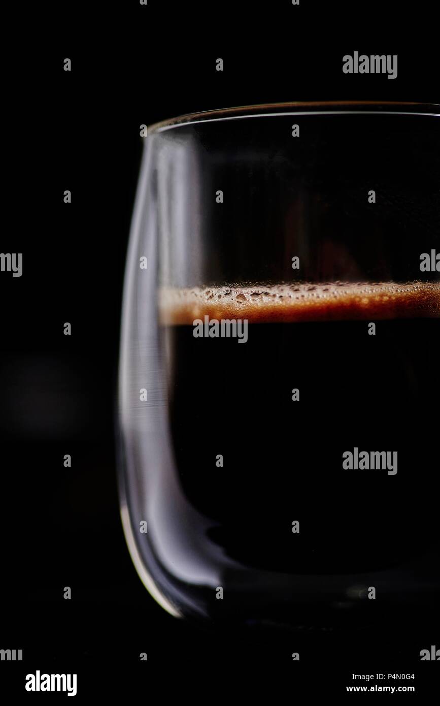 Una tazza di preparato di fresco nero caffè di fronte a uno sfondo nero Foto Stock