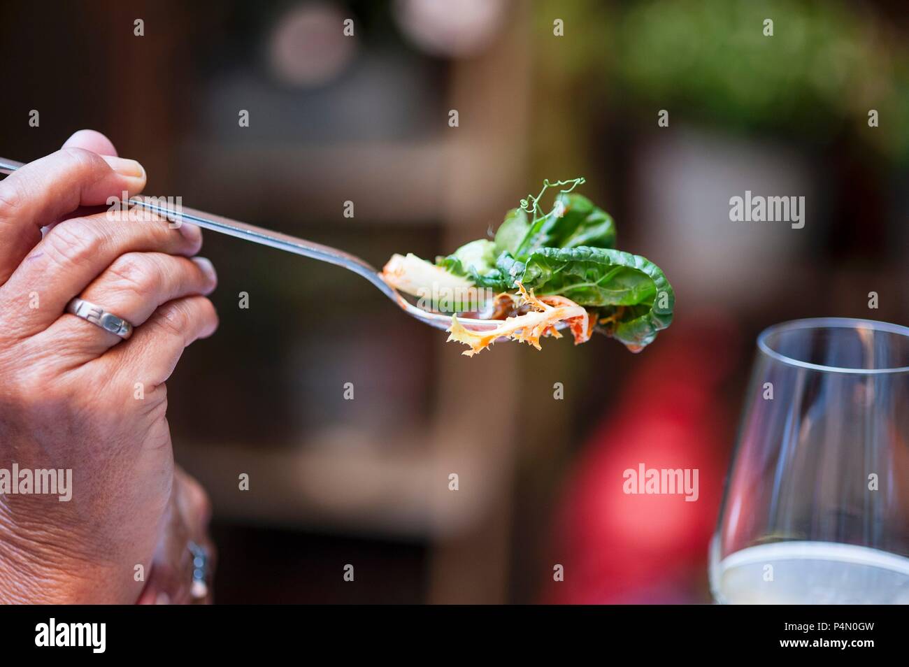 Una persona in possesso di una forcella di insalata Foto Stock