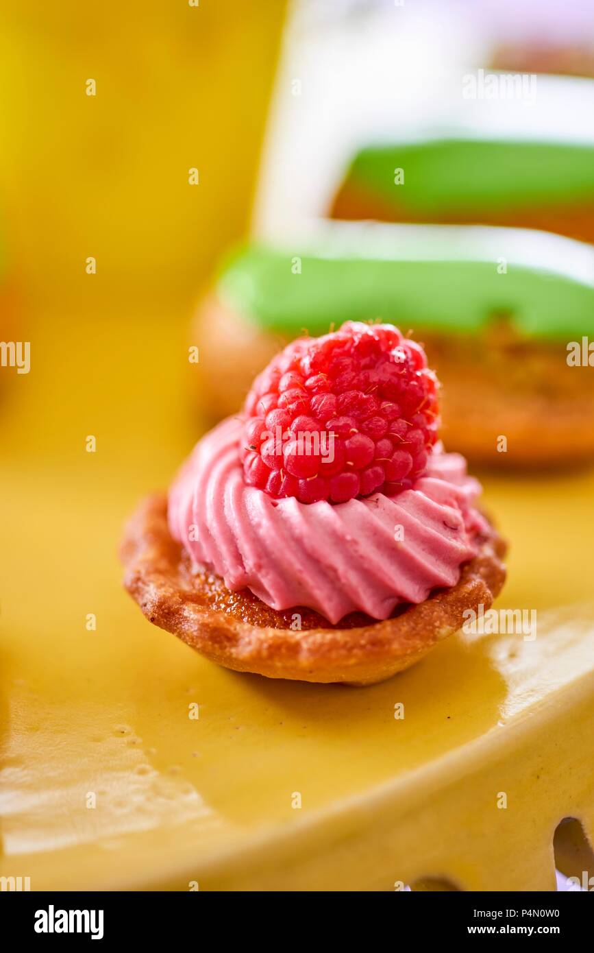Un petit four con lampone a un buffet di nozze Foto Stock