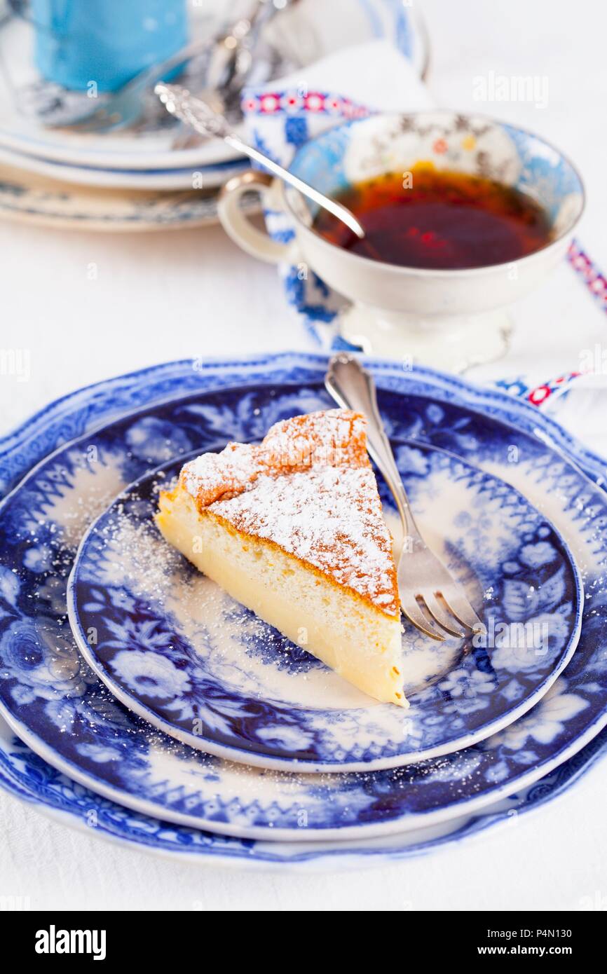 Un pezzo di budino alla vaniglia torta e una tazza di tè Foto Stock