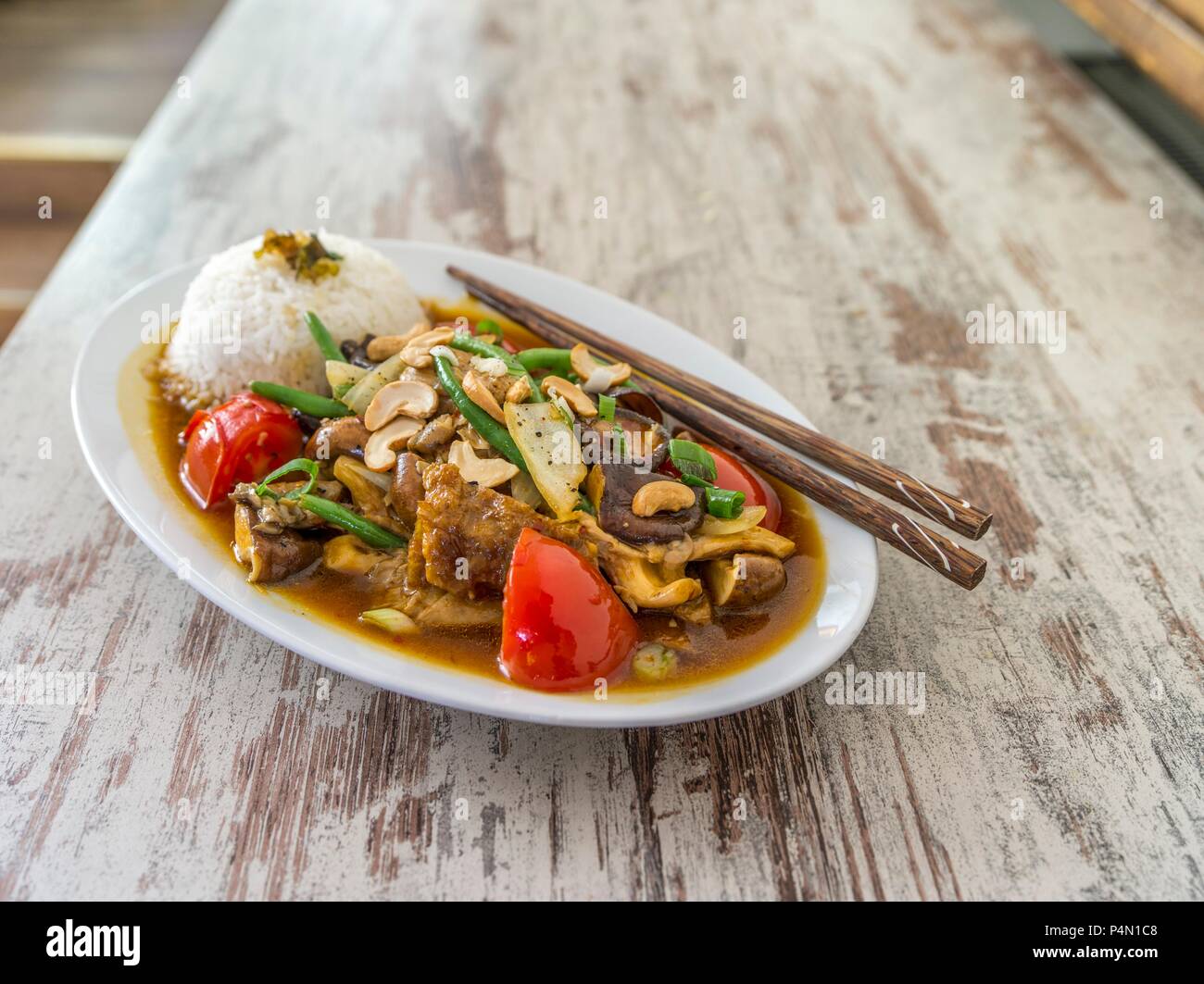 Pollo con funghi, noci di acagiù, pomodori, fagioli e riso (Asia) Foto Stock