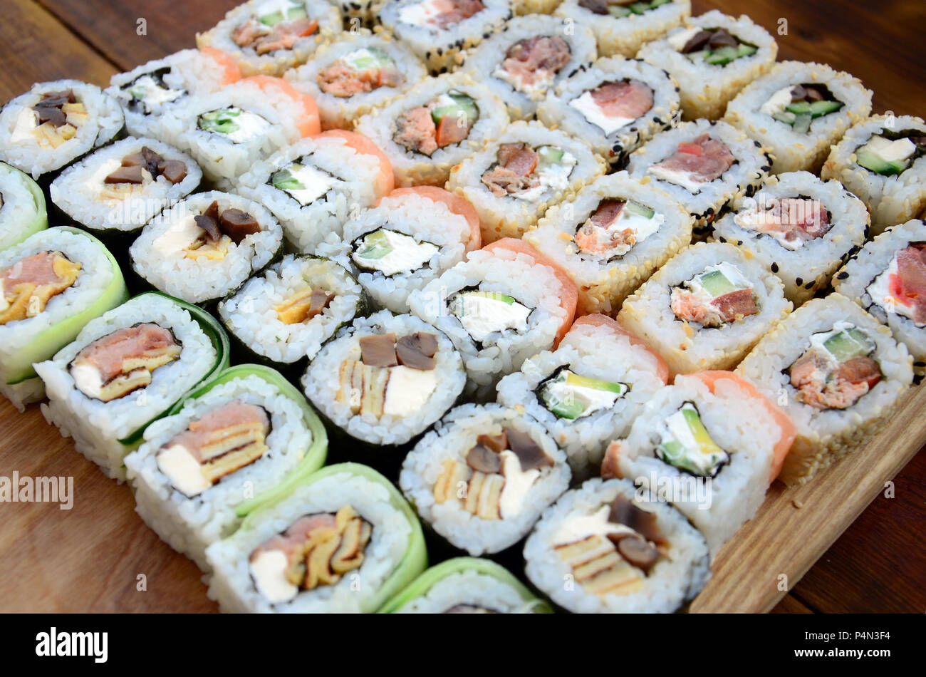 Close-up di un sacco di sushi rotoli con vari ripieni. Macro shot del classico cotto il cibo giapponese. Immagine di sfondo . Foto Stock