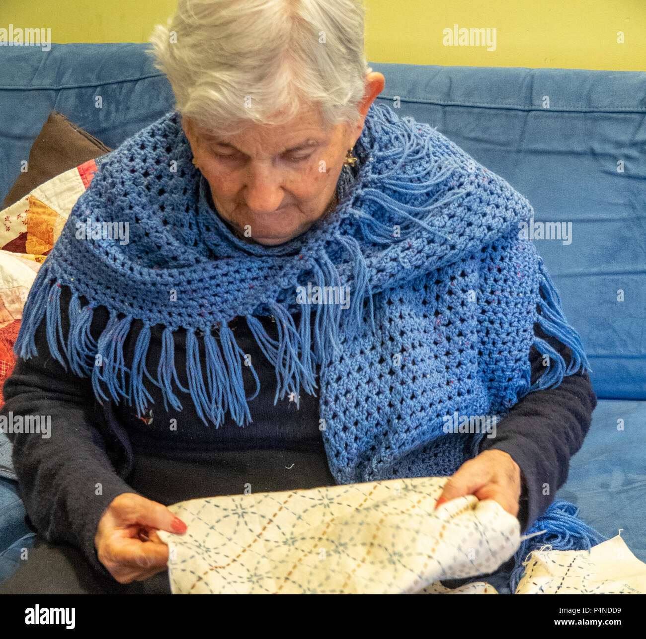 Una donna anziana con i capelli bianchi e indossa uno scialle ricamando  hobby Foto stock - Alamy