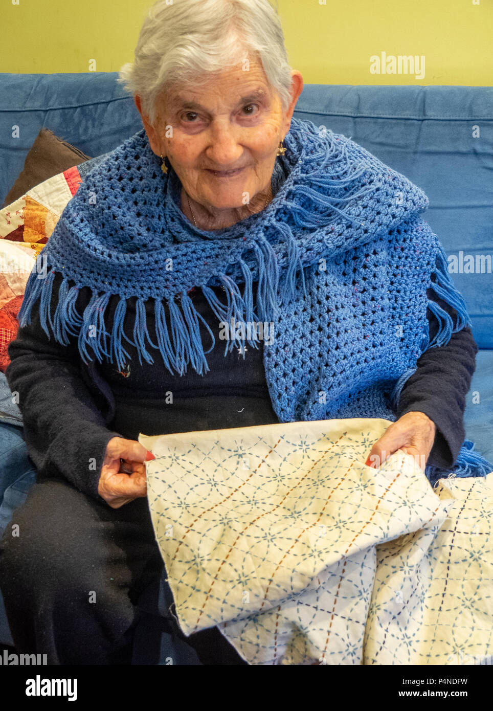 Una donna anziana con i capelli bianchi e indossa uno scialle ricamando  hobby Foto stock - Alamy