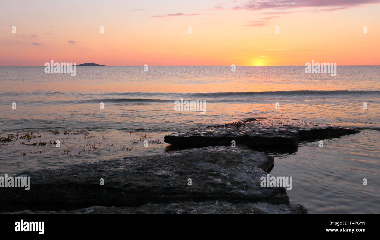 Tramonto sulla costa di Öland, con la piccola isola di 'Blå Jungfrun" (Blue Maiden) nella distanza. Foto Stock