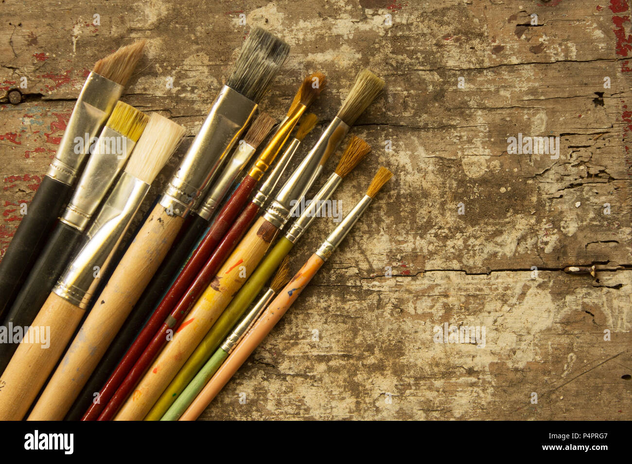 Diverse dimensioni di artista pennelli per dipingere su una tavola in legno rustico Foto Stock