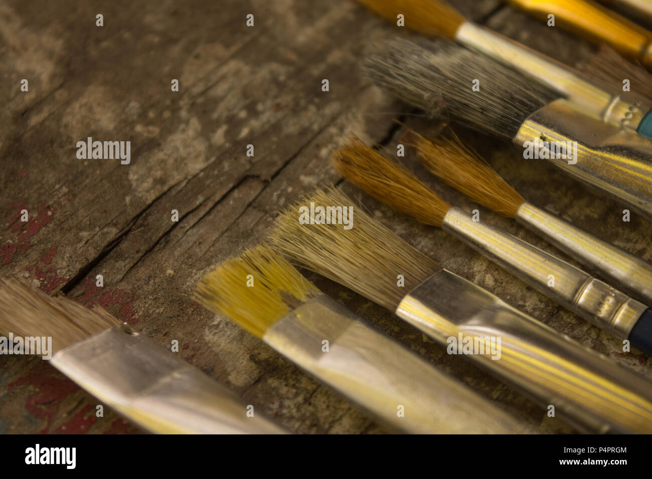 Vista superiore, dimensioni differenti pennelli per dipingere su una tavola in legno rustico, arte, disegno Foto Stock