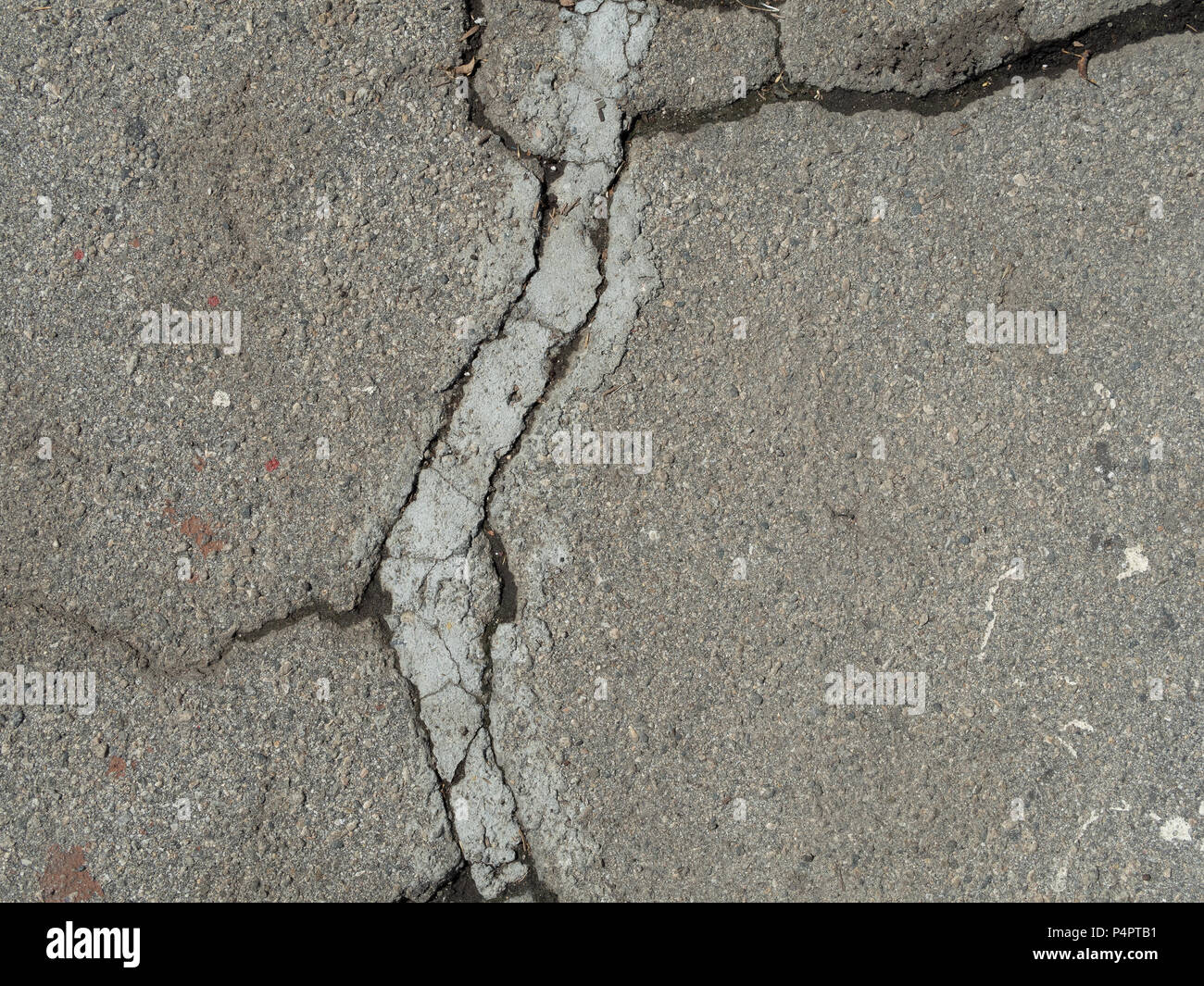 Asfalto Screpolato texture con patch di calcestruzzo Foto Stock