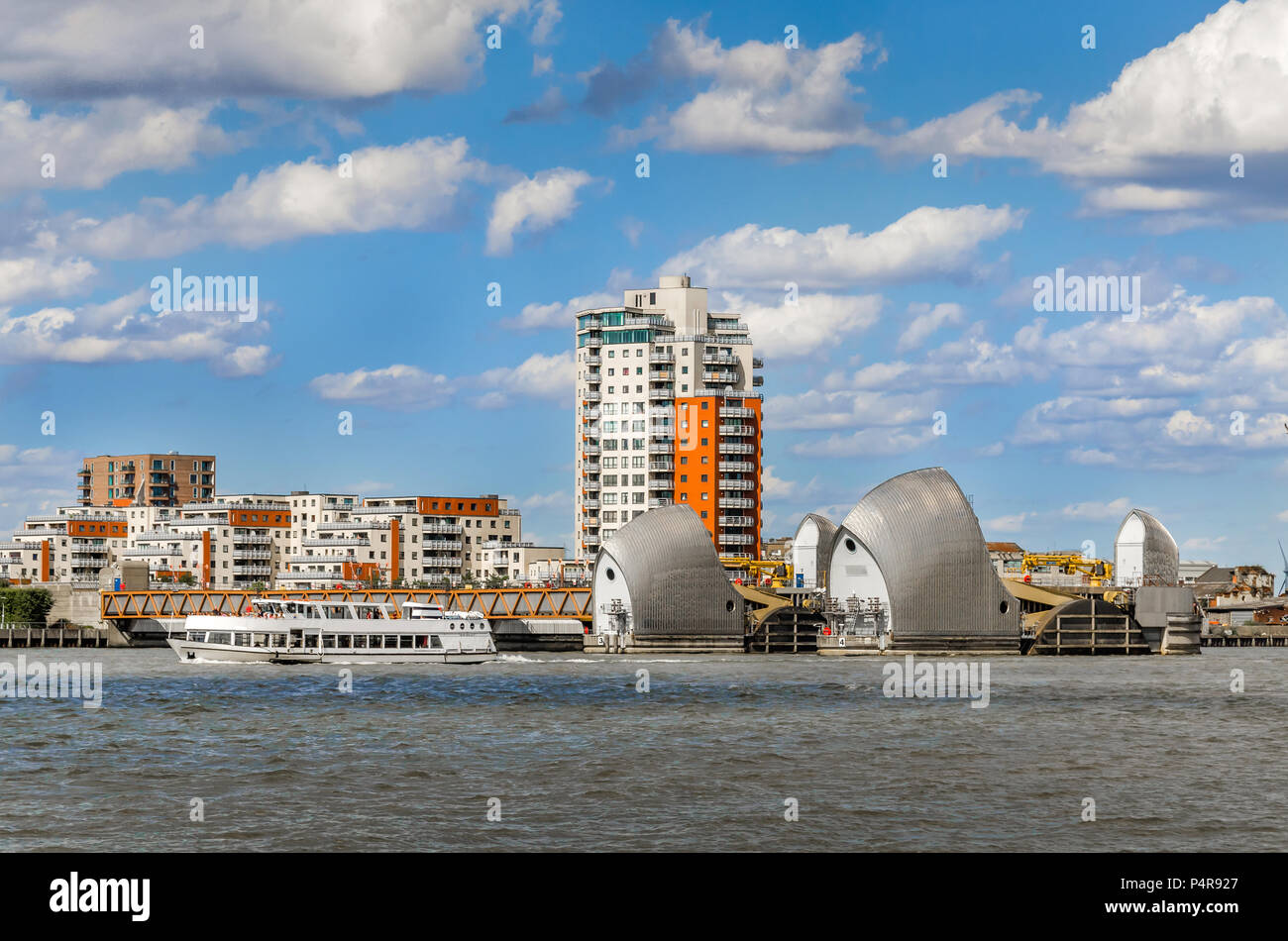 Vista la Thames Barrier in un giorno nuvoloso sotto il cielo blu a Londra. La Thames Barrier è una delle più grandi barriere mobili antiesondazione nel mondo. Foto Stock