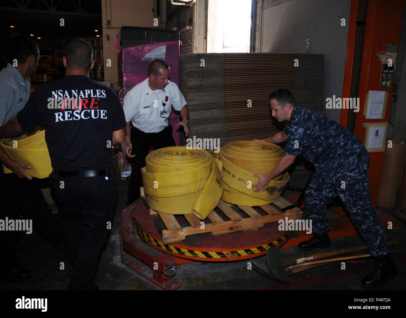 Da destra, U.S. Navy specialista della logistica di seconda classe Toptchenko vitali; Hanz cristiano, il fuoco di piombo ispettore navale di attività di sostegno (NSA) Napoli; e la nazionale italiana di vigili del fuoco Maurazio Patrone e Alessio Storto caricare le attrezzature antincendio su un pallet a Napoli, Italia, Agosto 11, 2010, per la spedizione di Russia. Il governo russo che ha richiesta ufficiale di assistenza da parte del Dipartimento della Difesa, è protettivo di ricezione le attrezzature antincendio e altri strumenti per la lotta contro incendi in corso nel paese. (DoD Foto Stock