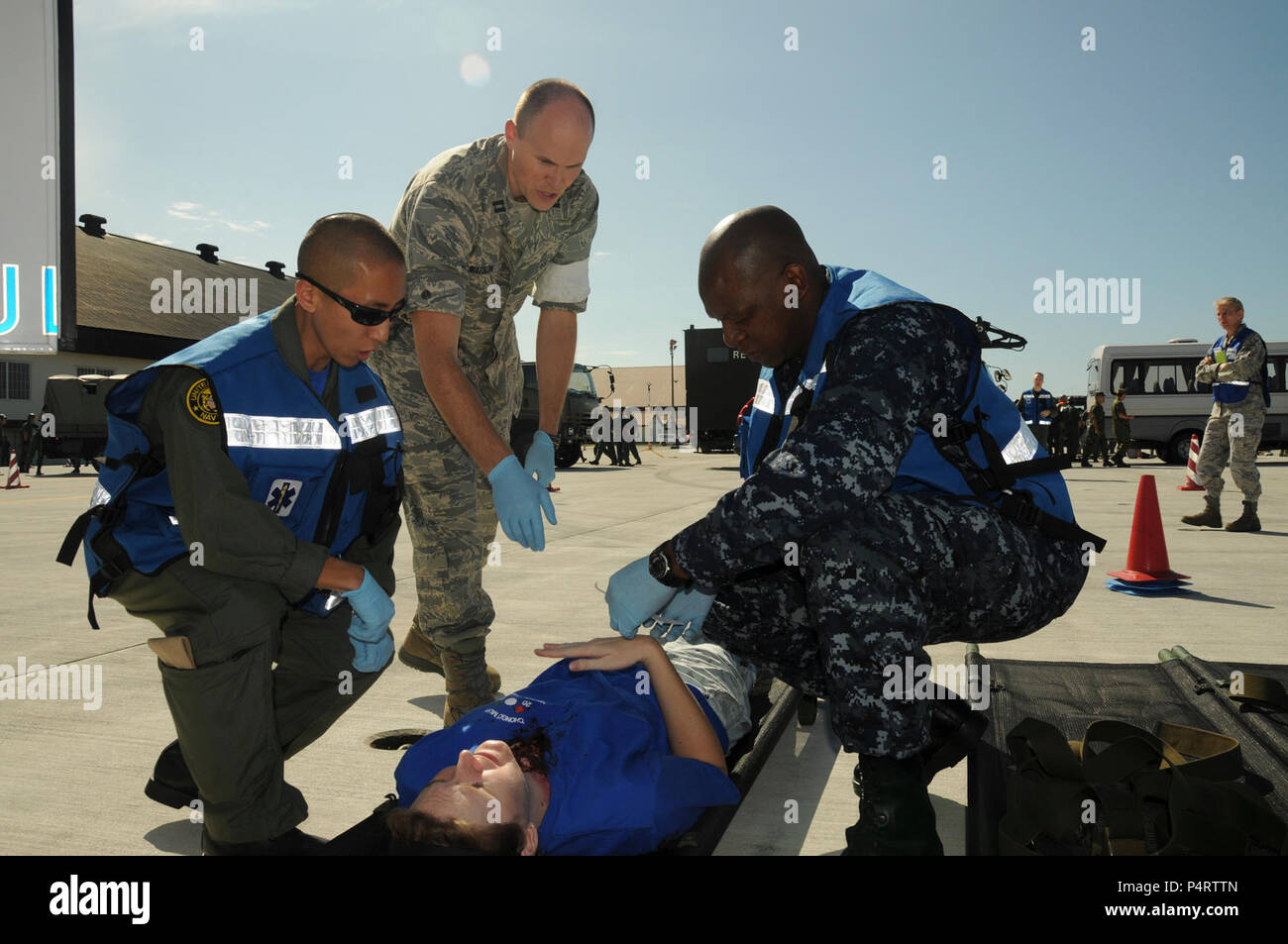 Stati Uniti Navy Lt. Sung Choi, sinistra, Air Force Capt. Robert Watson e Hospital Corpsman 2a classe Chamunorwa Chimhau eseguire una classificazione di diagnosi su una simulazione di incidente ferito durante un incidente rilevante esercizio di risposta su Misawa combatté Air Base in Giappone sett. 8, 2010. Il giunto, esercizio bilaterale con gli Stati Uniti Navy, U.S. Air Force e il giapponese Aria forza di autodifesa è progettato per migliorare l'interoperabilità in caso di una catastrofe. (DoD Foto Stock