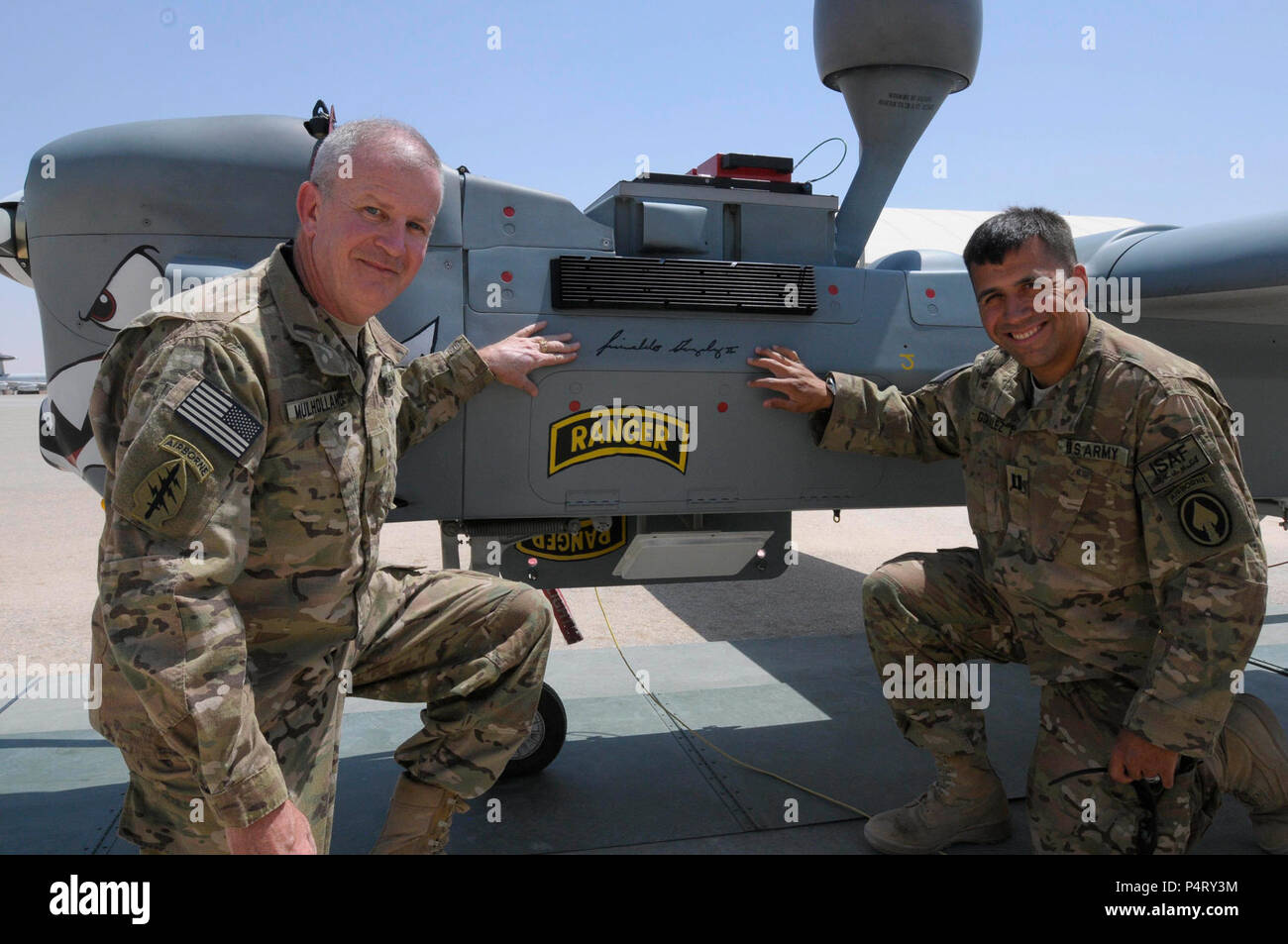 MAZAR-e Sharif, Afghanistan (21 luglio 2011) il Brig. Gen. Sean Mulholland e Capt. Reinaldo Gonzalez della Forza internazionale di assistenza alla sicurezza, del comando regionale del quartier generale del Nord, posano con un cacciatore drone chiamato per Gonzalez lo spirito di lotta in occasione di una cerimonia che si terrà su Camp Marmal. Gonzalez ha subito una frattura al collo e schiena in un incidente di formazione e ha combattuto attraverso un programma di riabilitazione per tornare a dovere, ora serve come aiutante di Mulholland, vice comandante di RC Nord. Foto Stock