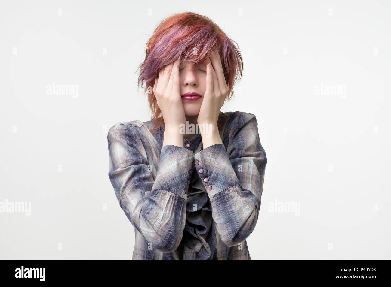 Ritratto di insolita piuttosto informale di donna con capelli colorati aventi terribile mal di testa. Strofinare la faccia cercando di basso un dolore. Foto Stock Ritratto di insolita piuttosto informale di donna con capelli colorati aventi terribile mal di testa. Strofinare la faccia cercando di basso un dolore. Foto Stock