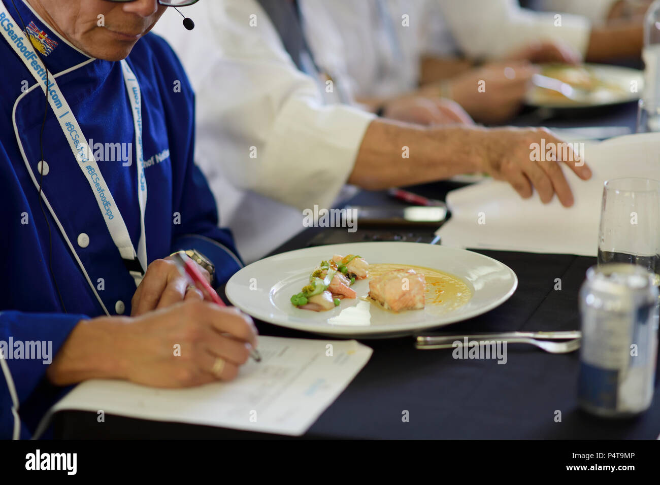 Primo piano di uno chef della concorrenza di giudicare rendendo note alla BC Festival di frutti di mare Chef Challenge 2018 in Comox Valley, British Columbia, Canada Foto Stock